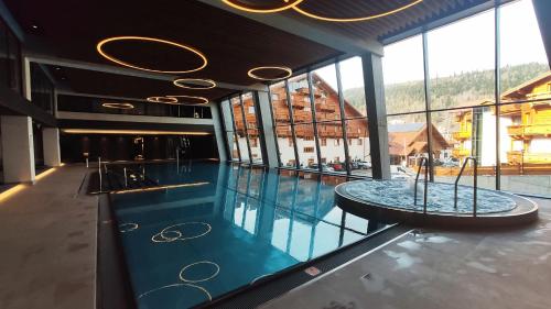 a swimming pool with a table in a building at Hotel Meta Resort & Vine SPA in Szczyrk