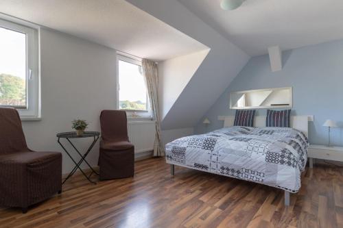 a bedroom with a bed and a chair at Haus-Godewind-Typ-4-1 in Binz