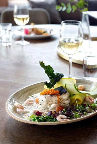 a plate of food on a table with wine glasses at Öijared Resort in Floda