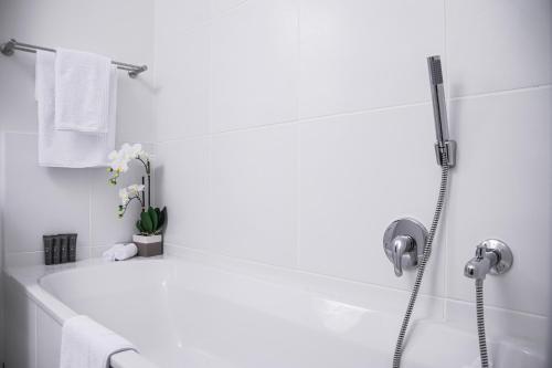 y baño blanco con bañera y ducha. en Residence at Montego en Sandton