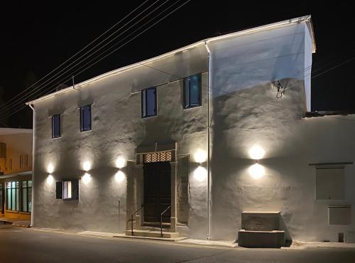 a white building with a door at night at The Courtyard Episkopi Guest Houses in Episkopi Lemesou