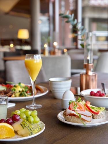 a table with plates of food and a glass of orange juice at Öijared Resort in Floda