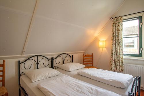 2 aparte bedden in een kamer met een raam bij Buitenplaats Villa 116 - Callantsoog in Callantsoog