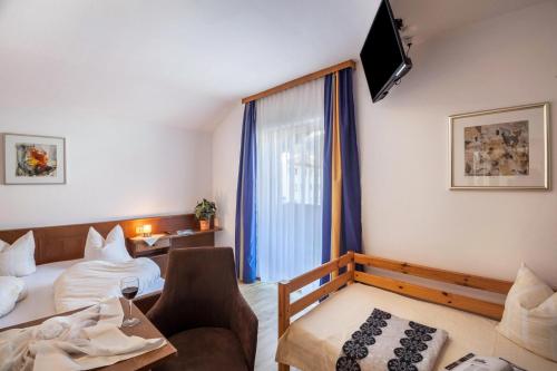 a room with two beds and a couch and a television at Ferienwohnung Brugger 4 Personen in Kaltenbach