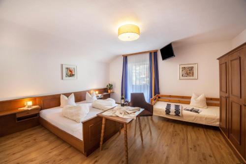 ein Hotelzimmer mit 2 Betten und einem Tisch in der Unterkunft Ferienwohnung Brugger 4 Personen in Kaltenbach