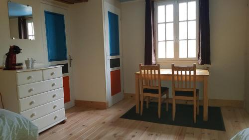 une cuisine avec une table et des chaises dans une pièce dans l'établissement Moulin2Roues, à Artannes-sur-Thouet