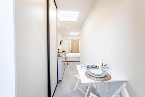 een witte eetkamer met een witte tafel en stoelen bij Beach Studio 35 in Zandvoort