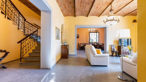 a living room with a white couch and a staircase at TENUTA DI MACERICCA 10, Emma Villas in Poggibonsi