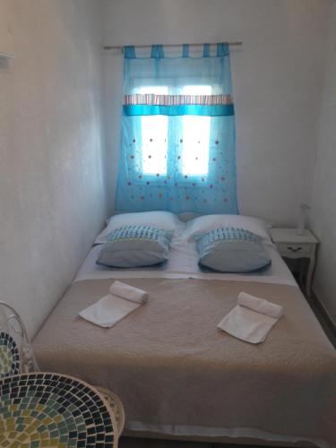 1 dormitorio con 1 cama con 2 almohadas y ventana en Robinson Medvidina Small room en Zastražišće