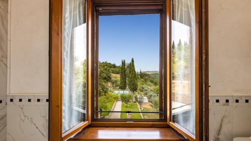 an open window with a view of a garden at TENUTA DI MACERICCA 10, Emma Villas in Poggibonsi