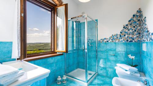 a blue tiled bathroom with a shower and a toilet at TENUTA DI MACERICCA 10, Emma Villas in Poggibonsi