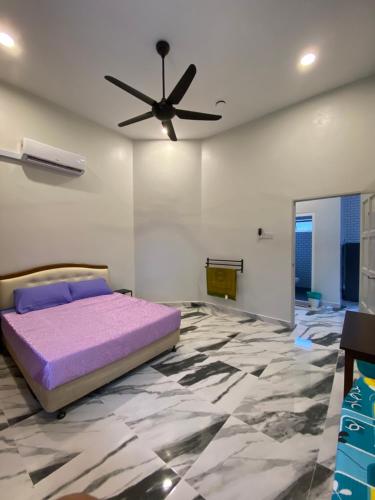 Bangi Utara Villa في كاجانغ: غرفة نوم مع سرير أرجواني ومروحة سقف
