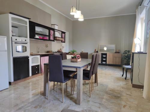 uma cozinha e sala de jantar com mesa e cadeiras em Appartamenti ai giardini em Palermo