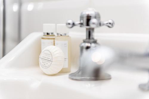 a bathroom sink with a silver faucet and a soap container at City Stay Apartments - Centro in Milton Keynes