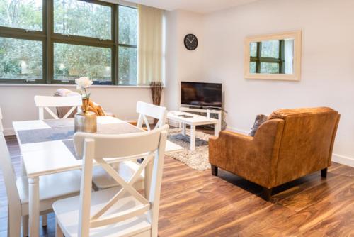a living room with a table and a couch and a television at City Stay Apartments - Centro in Milton Keynes