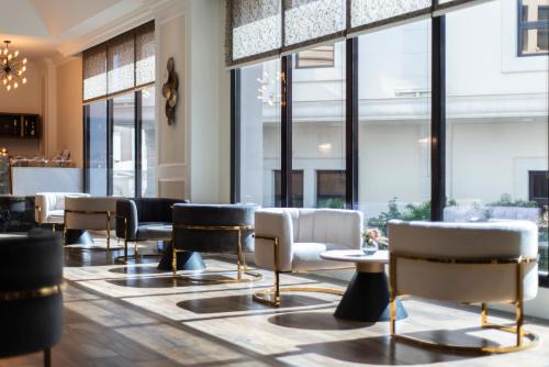 a lobby with chairs and tables and windows at Vittori Palace Hotel and Residences in Riyadh