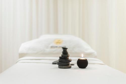 a stack of rocks with a candle on a bed at Vittori Palace Hotel and Residences in Riyadh
