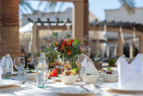 a table with a vase of flowers on it at Vittori Palace Hotel and Residences in Riyadh