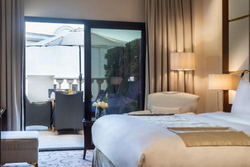 a hotel room with a large bed and a balcony at Vittori Palace Hotel and Residences in Riyadh