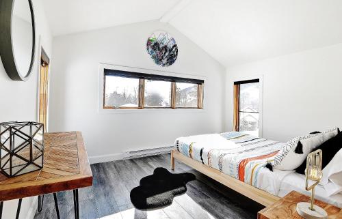 a bedroom with a bed and a table at Chalets Alpins - 12 Chemin Alpin in Stoneham