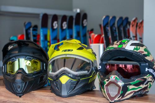two helmets sitting on top of a wooden table with skis at Ambassadori Goderdzi Hotel in Goderdzi