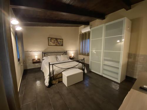 a bedroom with a bed and a table with a stool at Villa Conti in Giardini Naxos