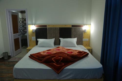 a bedroom with a bed with a blanket on it at Himalayan Canvas khajjiar in Khajjiar 