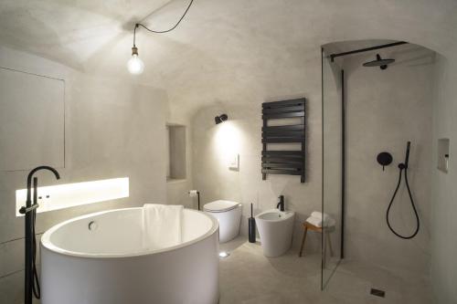 biała łazienka z wanną i toaletą w obiekcie INSTAURA Apartments w Genui