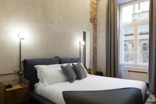 sypialnia z łóżkiem z 2 lampami i oknem w obiekcie INSTAURA Apartments w Genui
