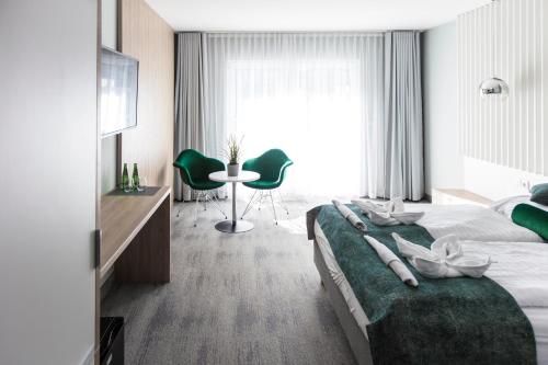 a hotel room with two beds and a table at Grand Laola Spa in Pobierowo