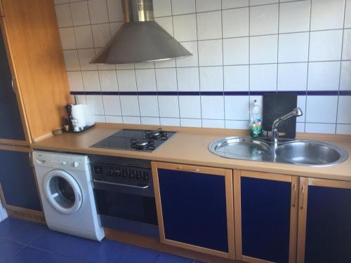 una cocina con fregadero y lavadora en Villa Sin Pena, en Tías