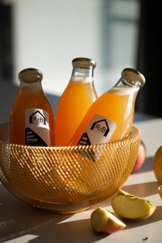 two bottles of orange juice in a bowl at Rozeboom Loft in Aartrijke