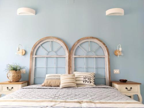 a bedroom with two large arched windows above a bed at Dimora Mediterranea in Mattinata