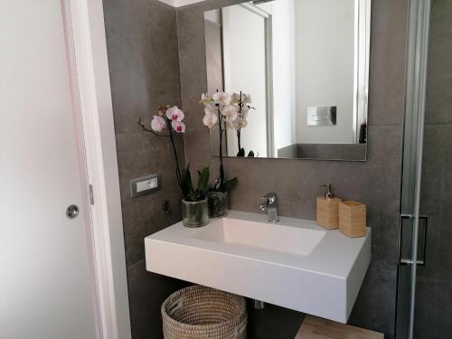 ein Badezimmer mit einem weißen Waschbecken und einem Spiegel in der Unterkunft Casetta Marconi....tra mare e storia! in Siculiana