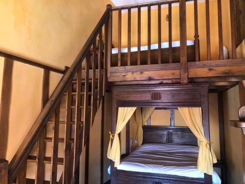 a wooden bunk bed in a room with stairs at Auberge du Renard'eau in Bèze