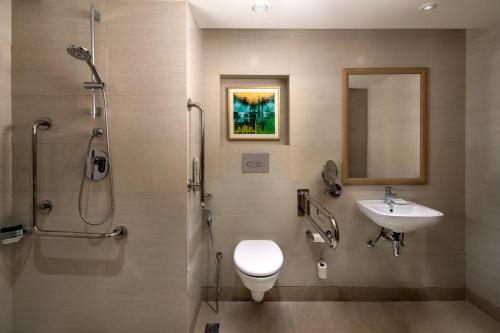 y baño con aseo, lavabo y ducha. en Holiday Inn Agra MG Road an IHG Hotel en Agra