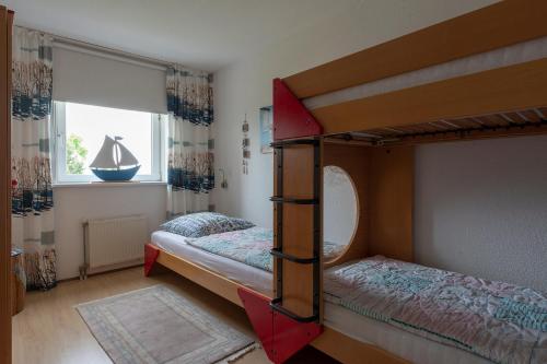 a bedroom with two bunk beds and a window at Residence Juliana appartement 65 - Julianadorp aan zee in Julianadorp