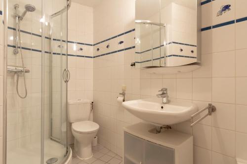 a bathroom with a toilet and a sink and a shower at Residence Juliana appartement 65 - Julianadorp aan zee in Julianadorp