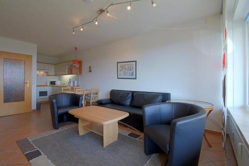 ein Wohnzimmer mit einer Couch und Stühlen und einem Tisch in der Unterkunft Apartment 255 in Hohegeiß