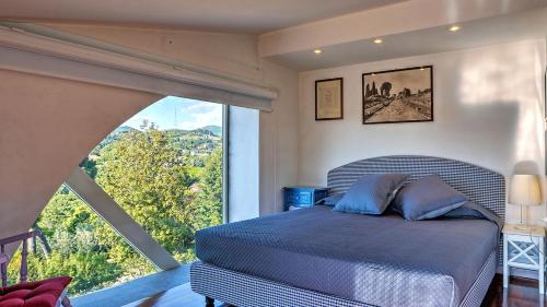 a bedroom with a bed and a large window at LANUVIUM 10, Emma Villas in Lanuvio