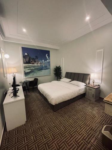 um quarto de hotel com uma cama, uma secretária e uma mesa em راحتي هوم em Al Rass