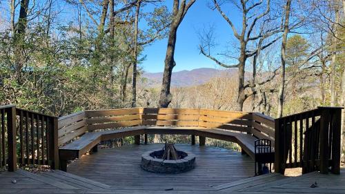 a wooden bench on a deck with a fire place at Barefoot Hills in Dahlonega