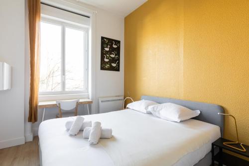 une chambre avec un lit blanc avec des serviettes dessus dans l'établissement DIFY Magique - Part Dieu, à Villeurbanne
