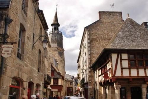 um grupo de edifícios numa rua com uma torre em T2 situé au cœur du centre historique de Dinan em Dinan