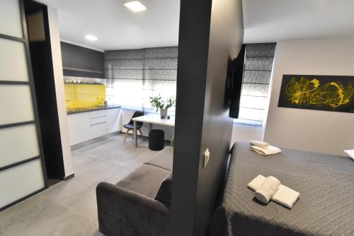 een kleine kamer met een bed en een keuken bij Mido Rooms in Zadar