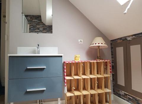 Una habitación con una cómoda azul y una lámpara. en Appartement cosy pour une pause sereine et chaleureuse, en Le Mont-Dore