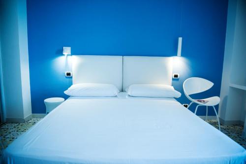 a bedroom with a white bed with a blue wall at Hotel Villa Felice Relais in Amalfi