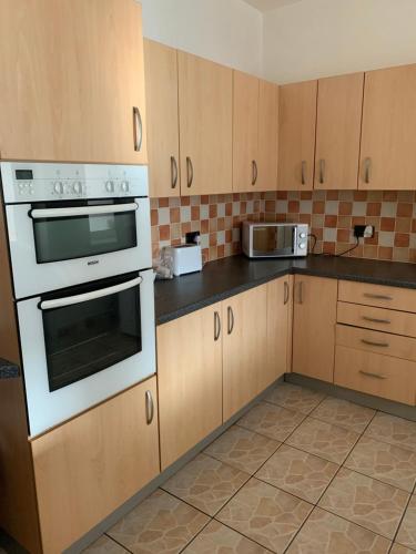 a kitchen with wooden cabinets and a white oven at Beautiful house in a perfect location in Saint Annes on the Sea