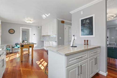 a kitchen and dining room with white cabinets and a table at @ Marbella Lane - Buckingham Place Laundry + P in Pacifica