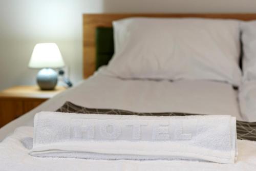 a bed with a white towel on top of it at Garni Hotel Mala Moskva in Bela Palanka